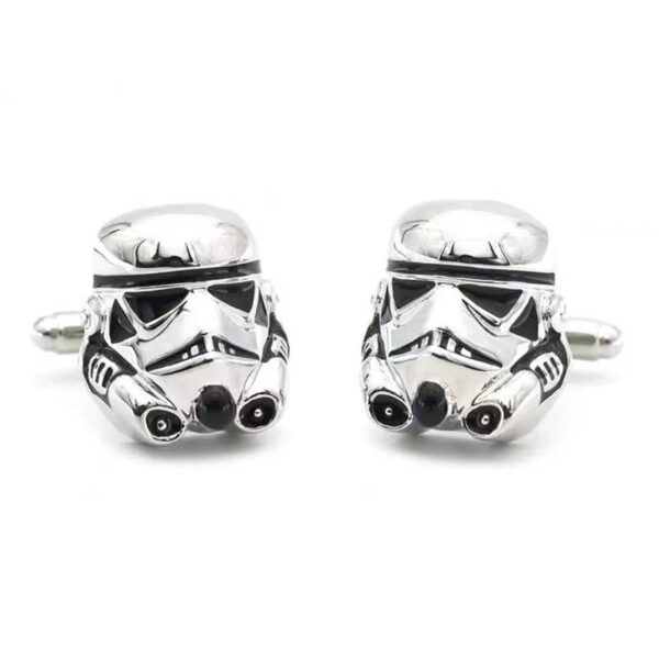 Gros plan sur des boutons de manchette en forme de casque chromé de science-fiction.